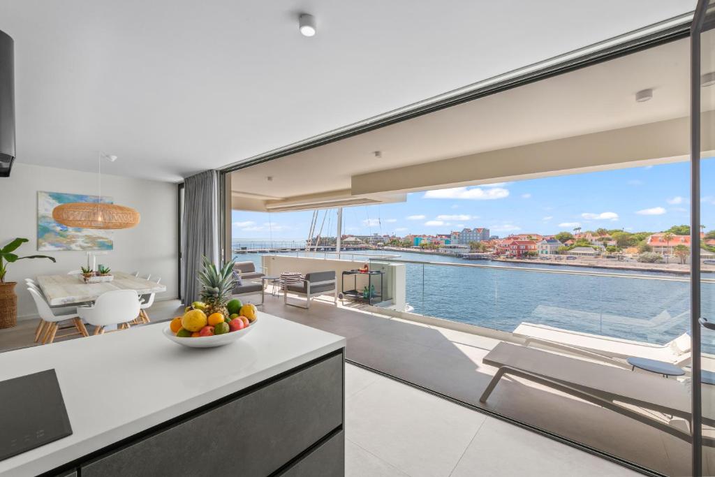 una cucina e un soggiorno con vista sull'acqua di The Wharf 7E city apartment, overlooking Annabay, downtown Willemstad a Willemstad