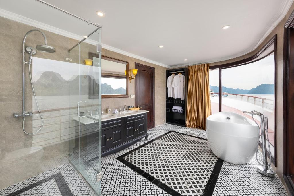 uma casa de banho com uma banheira e um chuveiro em vidro. em Aqua Of The Seas Cruise Halong em Ha Long