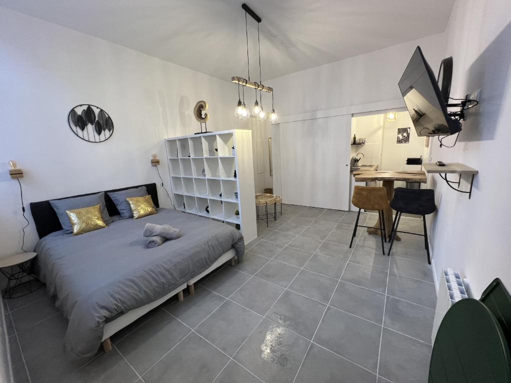 une chambre avec un lit et un bureau dans une pièce dans l'établissement Le Studio de la Grand Place, à Arras