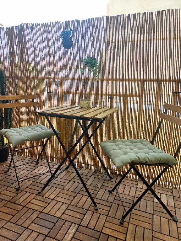 une table et deux chaises sur une terrasse dans l'établissement Appartement Bambou, à Sète