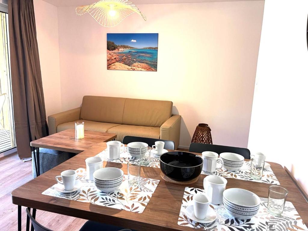 une salle à manger avec une table et un canapé dans l'établissement Cala Rossa T2 Neuf à 800 m de la mer appart n 81, à Lecci