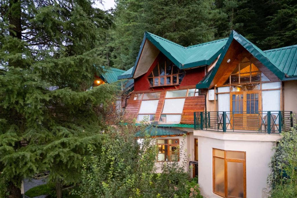 a large wooden house with a green roof at StayVista at Wood House Retreat in Shimla