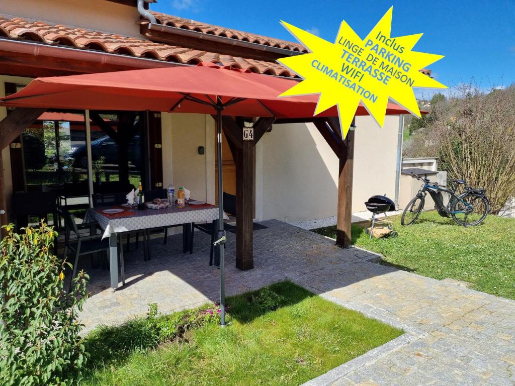 une table sous un parapluie rouge dans l'herbe dans l'établissement Les Hauts de Sarlat G4 - Clim Piscine Parking WiFi 2 Chambres, à Sarlat-la-Canéda