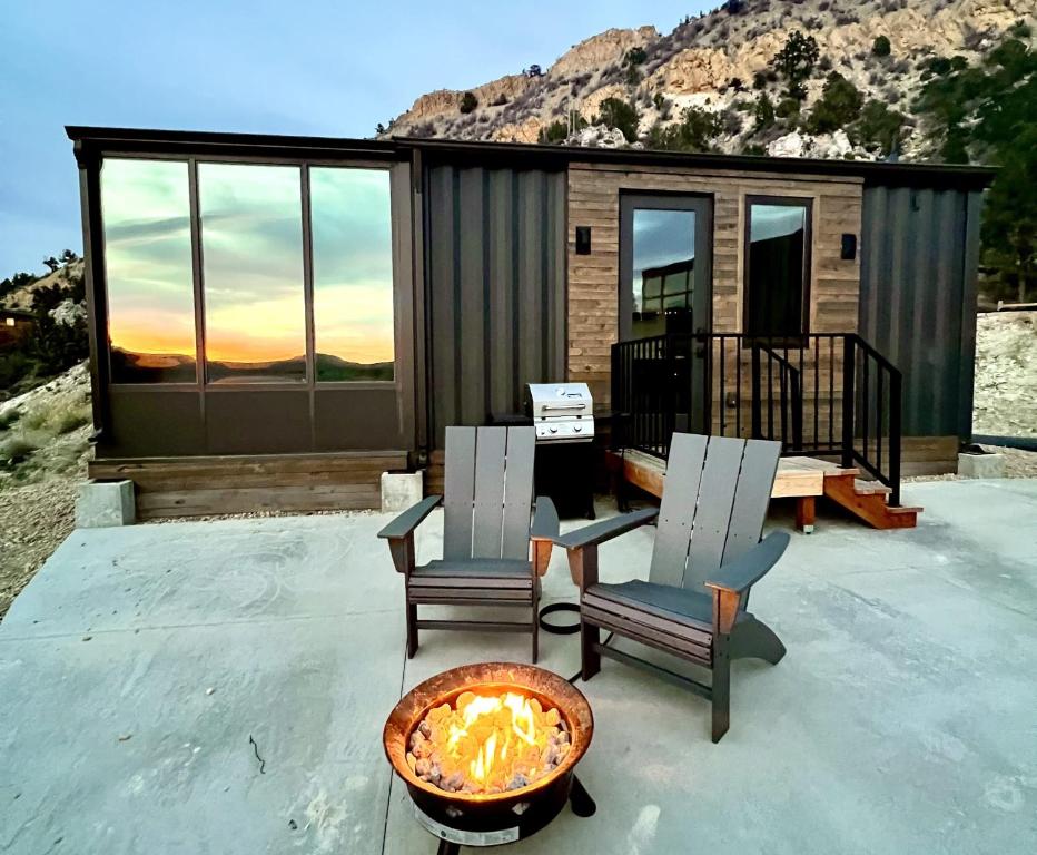 a tiny house with two chairs and a fire pit at Hidden Abode in Orderville