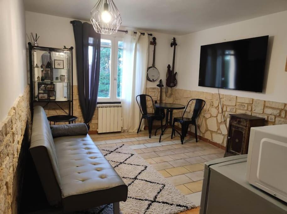 un salon avec un canapé et une table dans l'établissement Studio avec chambre Camargue, à Arles