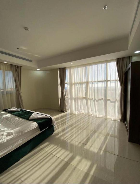 a bedroom with a bed and a large window at فندق فخر ينبع 5 in Yanbu