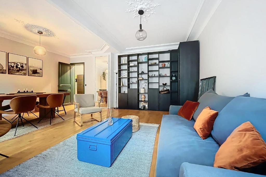 un salon avec un canapé bleu et une table dans l'établissement Spacious apartment near Gare du Nord and Est, à Paris