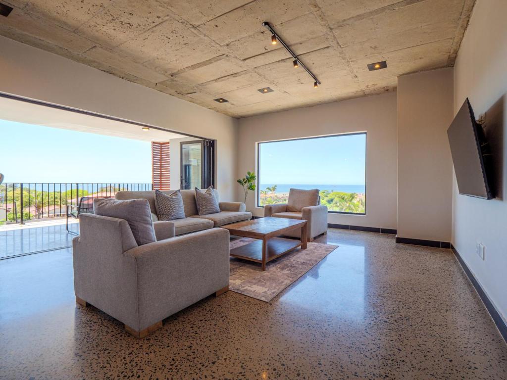 a living room with two couches and a tv at The Lofts on Manaar in Durban