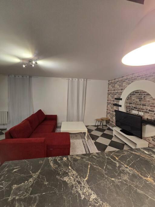 - un salon avec un canapé rouge et une cheminée dans l'établissement maison de vacances proche blaye, à Mazion