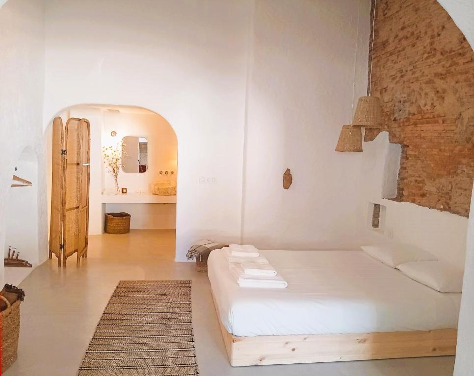 a white room with a bed and a hallway at Casas Velhinhas - Apartº Aconchego e Apartº Calmaria in Estremoz