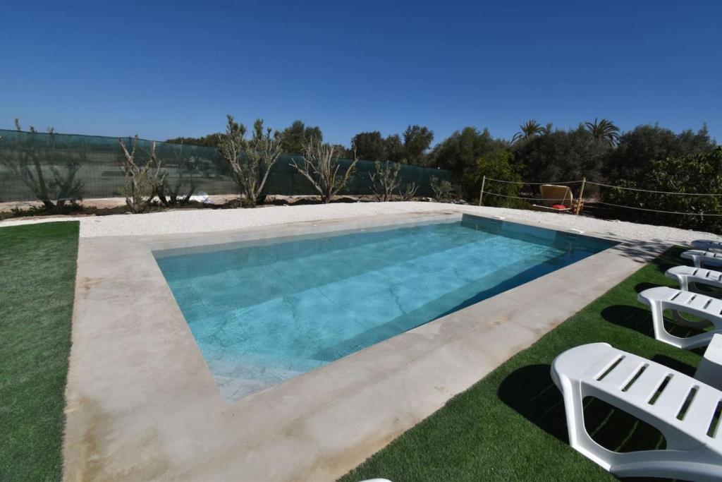 a swimming pool with lounge chairs in the grass at Sweetstaybykw Amplia Casa de Campo con Piscina in Asprillas