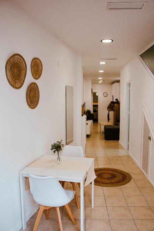 a dining room with a white table and white chairs at Loft Molino de Erillas in Alora