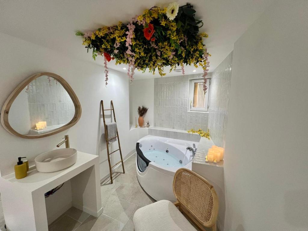 une salle de bain avec une baignoire, un lavabo et un miroir dans l'établissement Charmante escapade, à Perpignan