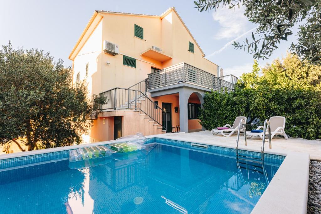 a villa with a swimming pool in front of a house at Pietro in Korčula