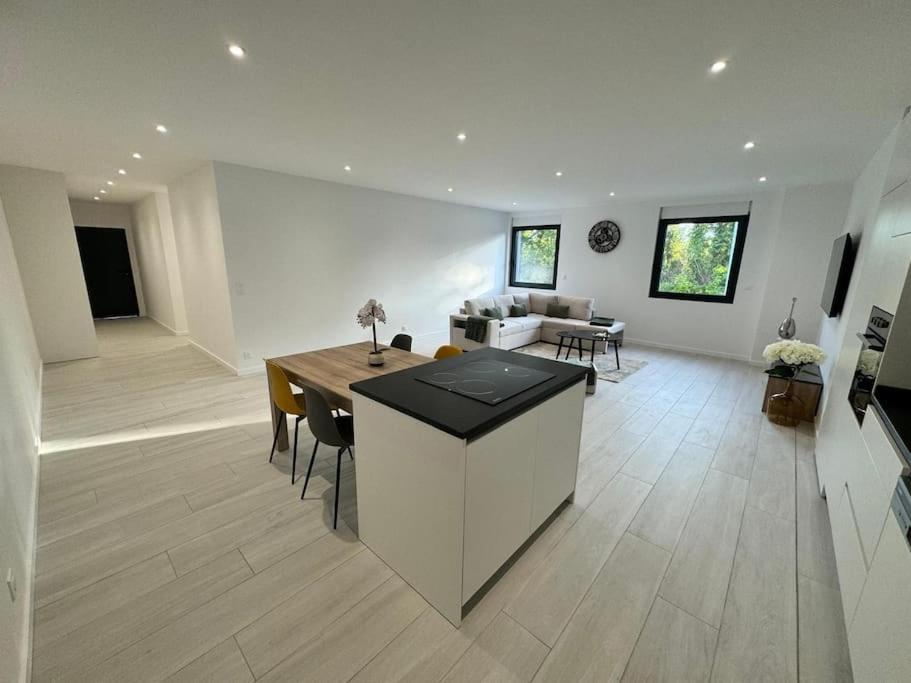 une cuisine et un salon avec une table et des chaises dans l'établissement Appartement meublé de 120 m2, à Coudun