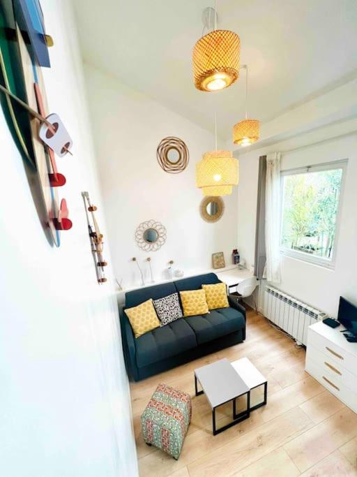 un salon avec un canapé et une table dans l'établissement Jolie Mini Maison Lovely Tiny House, à Vitry-sur-Seine