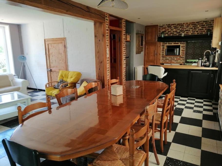 une salle à manger avec une table et des chaises en bois dans l'établissement Au petit bonheur à la campagne, à Lederzeele