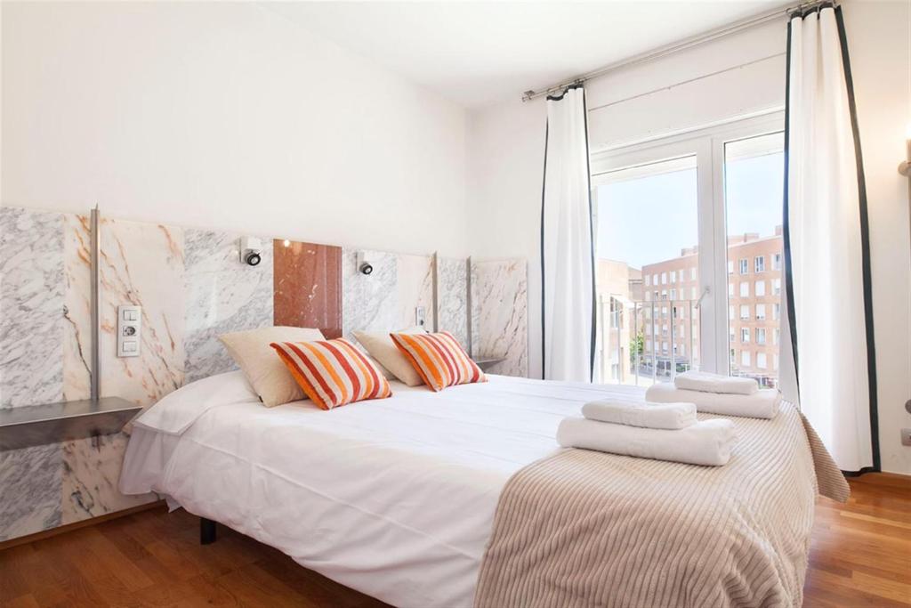 Un dormitorio con una gran cama blanca con almohadas. en Stay U-nique Apartments Salvador Espriu, en Barcelona