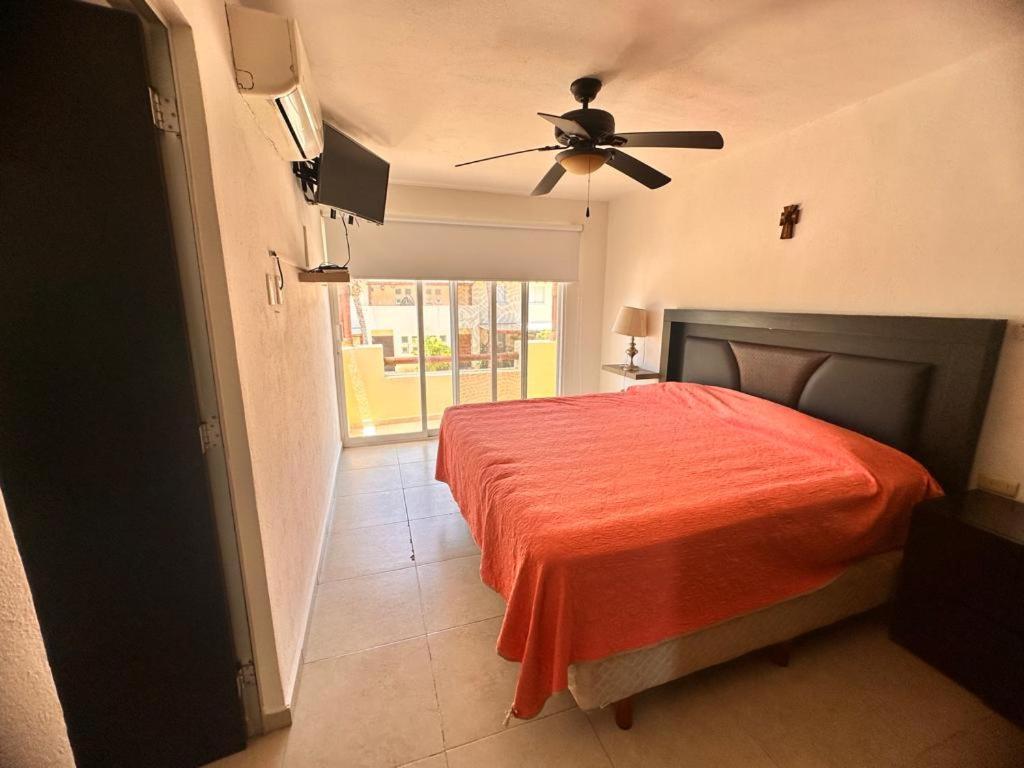 une chambre avec un lit et un ventilateur de plafond dans l'établissement Residencial Terrasol, à Acapulco
