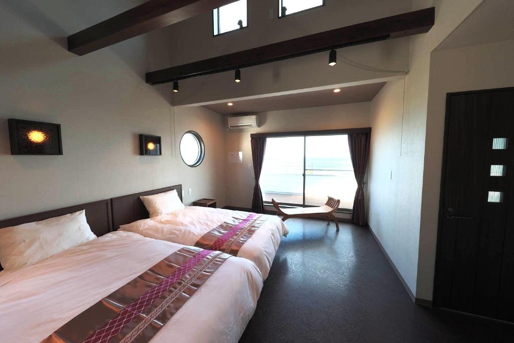 a bedroom with a large bed and a large window at Kanasha Building A - Vacation STAY 49732v in Ōkachi