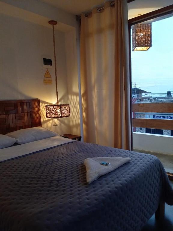 a bedroom with a bed and a large window at Hotel Chicama Home and lounge in Puerto Chicama
