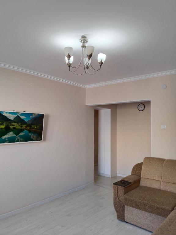 un salon avec un canapé et un tableau au mur dans l'établissement Минималистичная квартира, à Kyzylorda