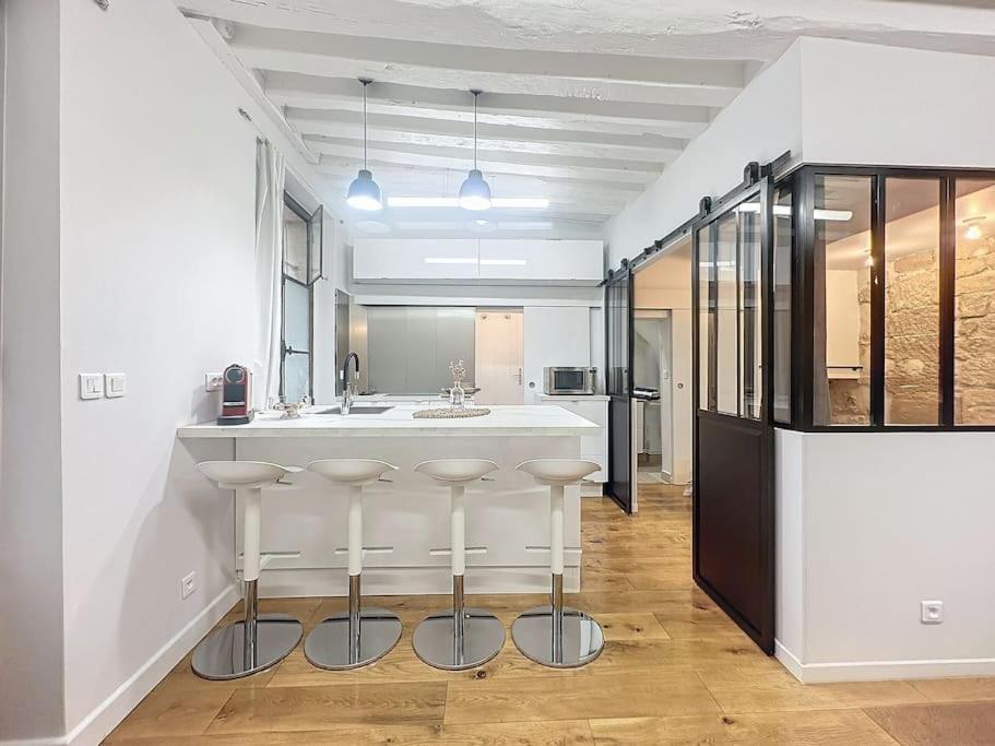 - une cuisine avec un bar avec des tabourets au milieu dans l'établissement Loft en plein coeur du Marais, à Paris