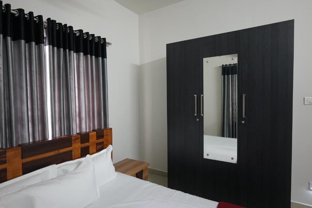 Postel nebo postele na pokoji v ubytování Swapna Home Suites