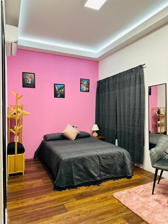 a bedroom with a pink wall and a bed at Casa Don José TULIPANES Suite in Oaxaca City