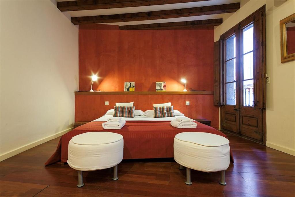 a bedroom with a bed with two white chairs at Friendly Rentals Manel in Barcelona