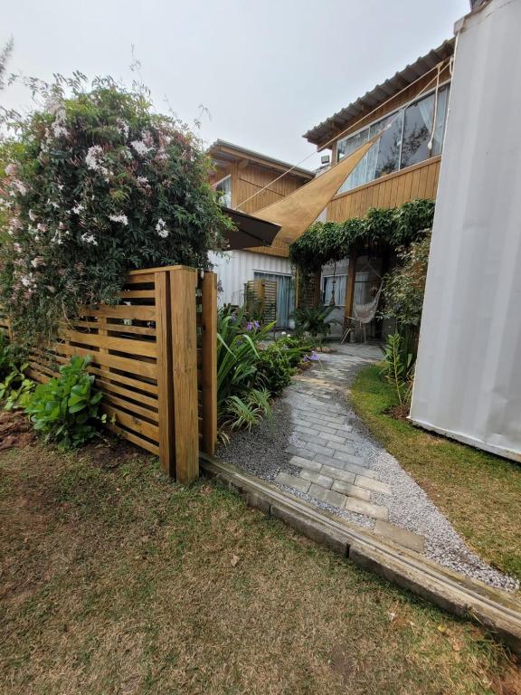 a wooden fence in front of a house at Moã do Mar Suítes in Guarda do Embaú