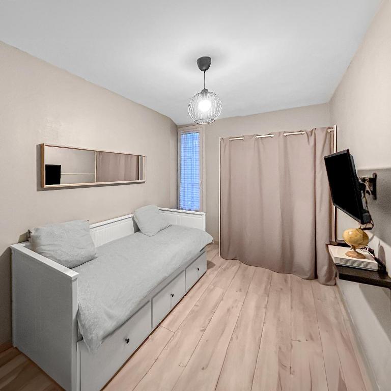 une chambre avec un lit et une télévision dans l'établissement LE Cosy De La Gare, à Tours