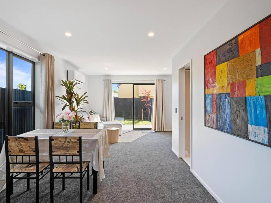 a dining room with a table and a painting on the wall at Spa Hideaway in Central City with Parking in Christchurch
