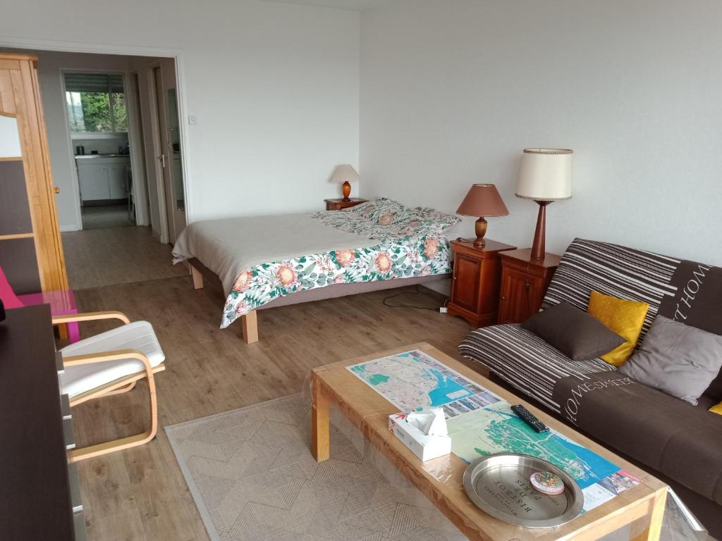 un salon avec un lit et un canapé dans l'établissement Central et calme, vue ville et mer, parking privé, ascenseur, au Havre