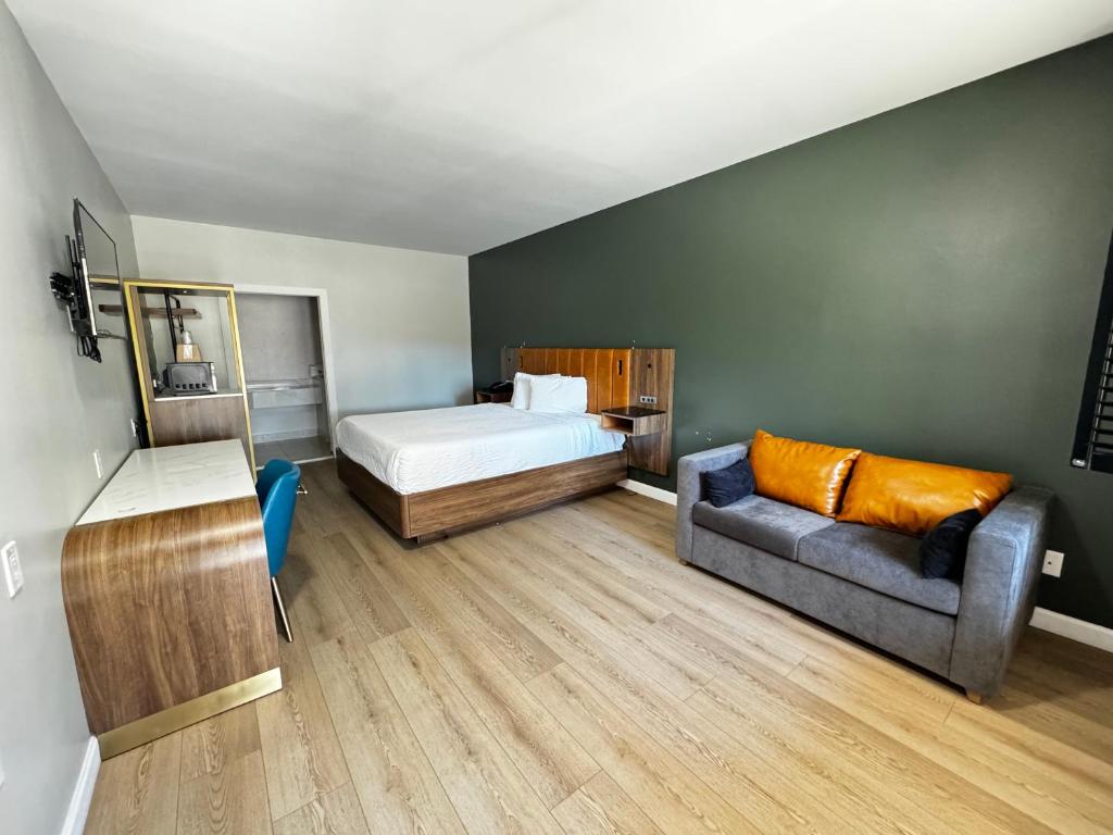 Un dormitorio pequeño con una cama y un sofá. en SureStay by Best Western Morgan Hill, en Morgan Hill