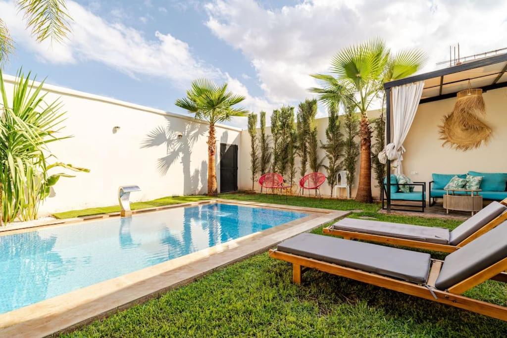 El MakinaVilla michlo的棕榈树房子后院的游泳池