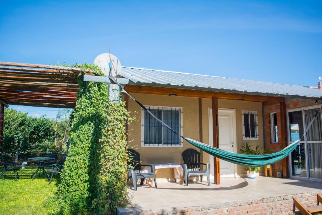 ein Haus mit einer Hängematte auf einer Terrasse in der Unterkunft La Mora Cabañas in Villa Urquiza