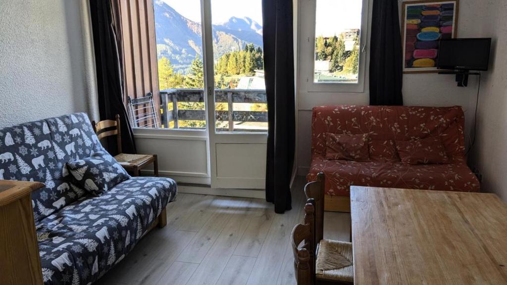 un salon avec un canapé, une table et une fenêtre dans l'établissement Résidence Rond-point-pistes I - Maxi studio 6 pers. n° 44 A le rond point des pistes 1 centre station MAE-0271, à Orcières