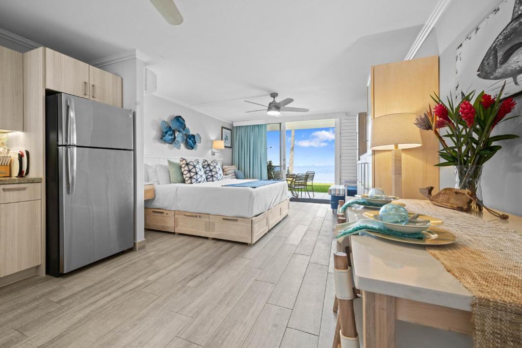 a bedroom with a bed and a kitchen with a table at Napili Shores I174 in Kapalua