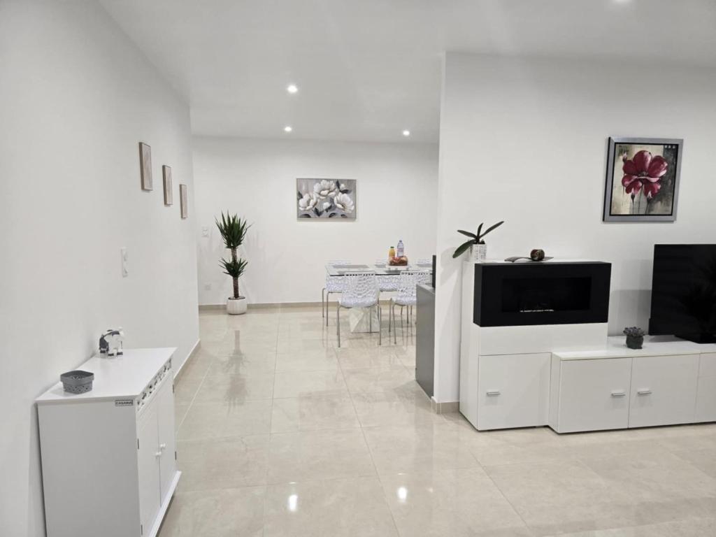 un soggiorno bianco con una televisione e un tavolo di Maison Challans a Challans