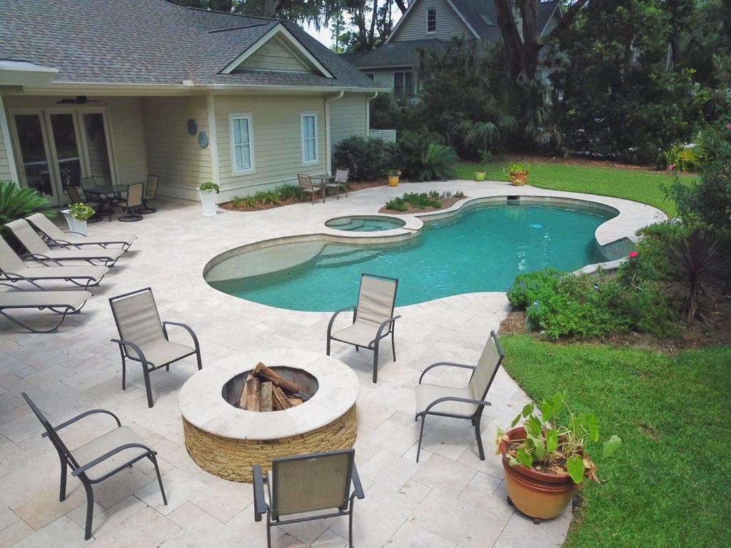 un patio con sedie e una piscina con tavolo e braciere di Outdoor Cabana - Firepit - Private Pool & Spa - Pet Friendly - 72 Baynard Cove Road a Hilton Head Island