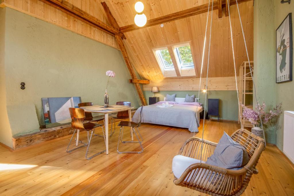 a room with a bed and a table and chairs at Großes City-Loft - Schwingstuhl & Sterne in Klagenfurt