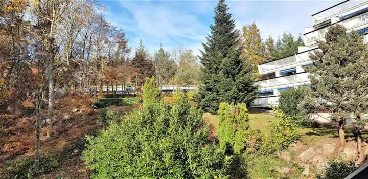 un bâtiment avec des arbres devant un bâtiment dans l'établissement Studio en résidence, aux Trois-Epis, à Turckheim