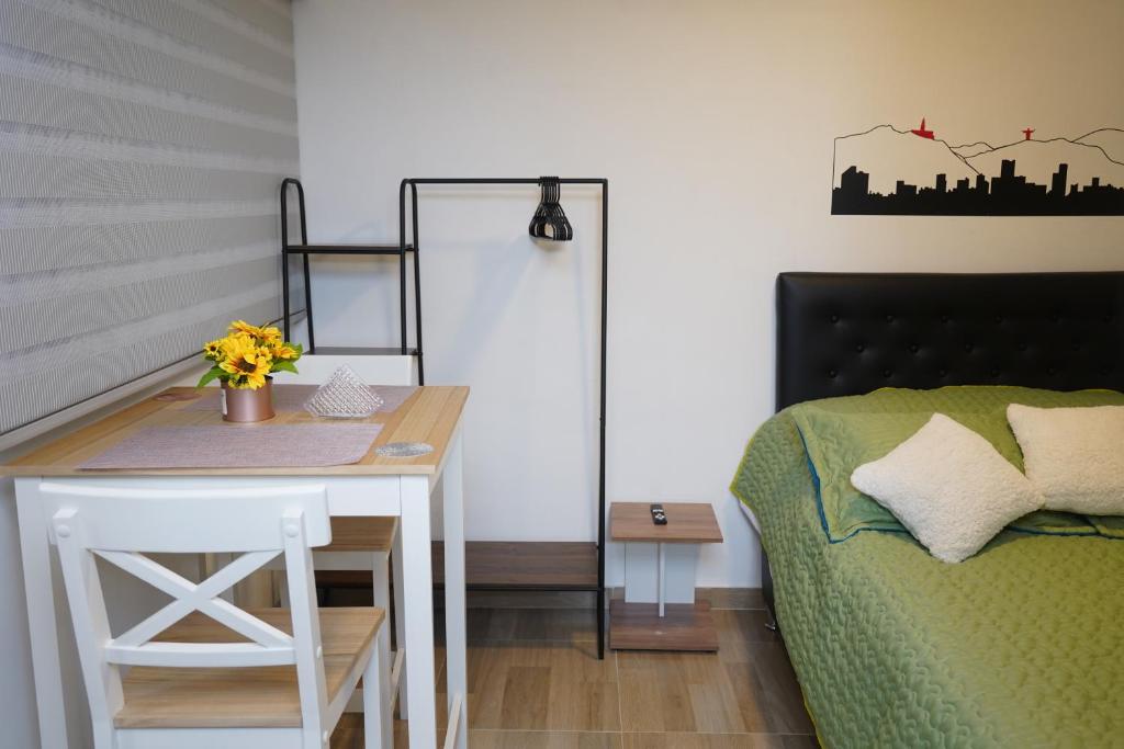 1 dormitorio con escritorio, 1 cama y 1 mesa en Apartamento Hortensia - Casa Tartaruga Bogotá, en Bogotá