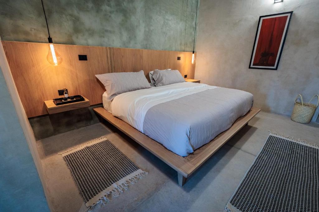 a bedroom with a large bed with a wooden headboard at Casa 1800 Oaxaca Boutique Hotel in Oaxaca City