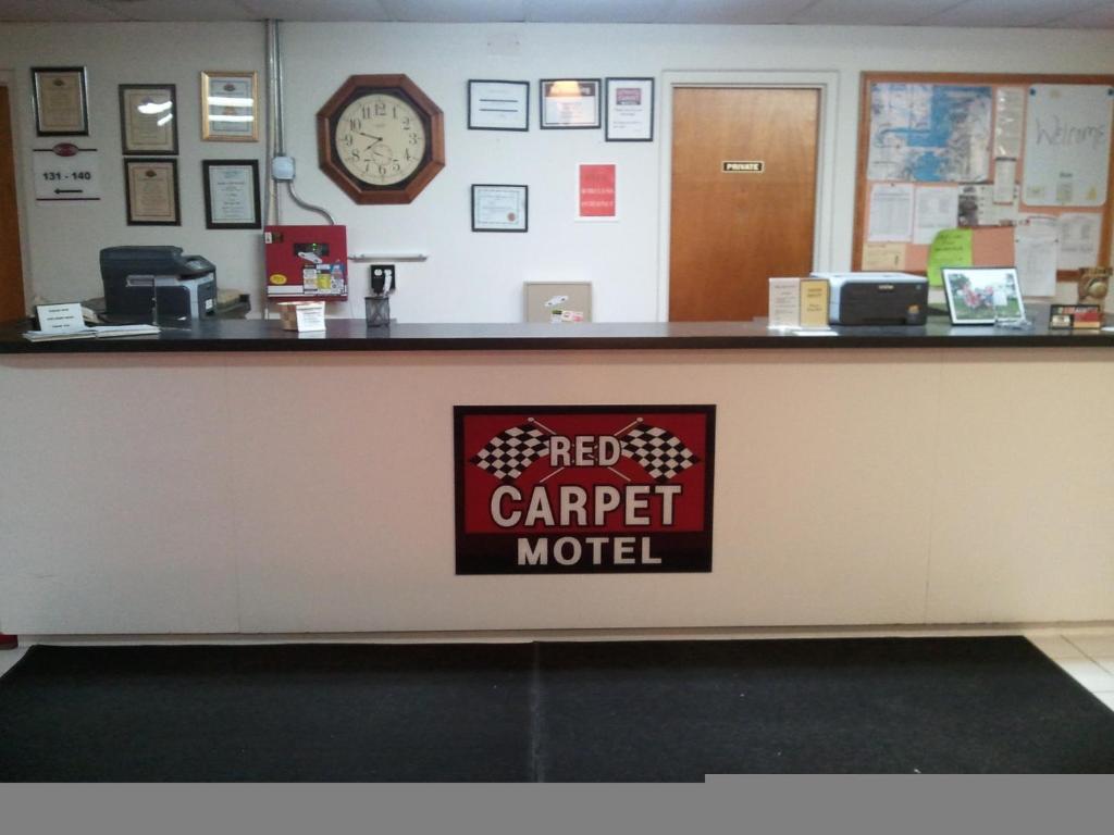 un comptoir d'hôtel avec un panneau indiquant le tapis motel dans l'établissement Red Carpet Motel - Knoxville, à Knoxville