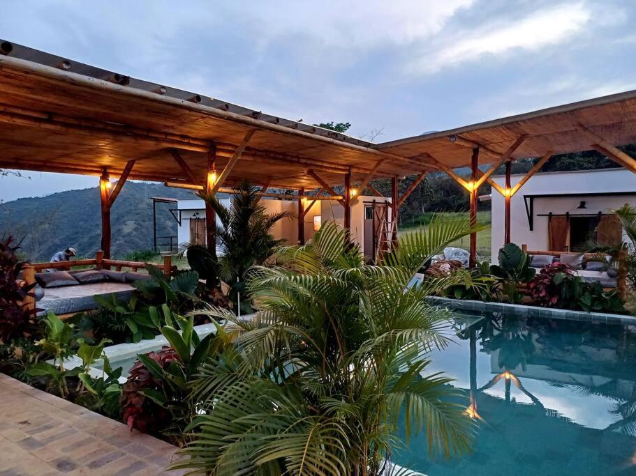 une maison avec une piscine et une pergola en bois dans l'établissement Piscina-paisaje-calma y confort-Villa Luz de luna, à Santa Fe de Antioquia