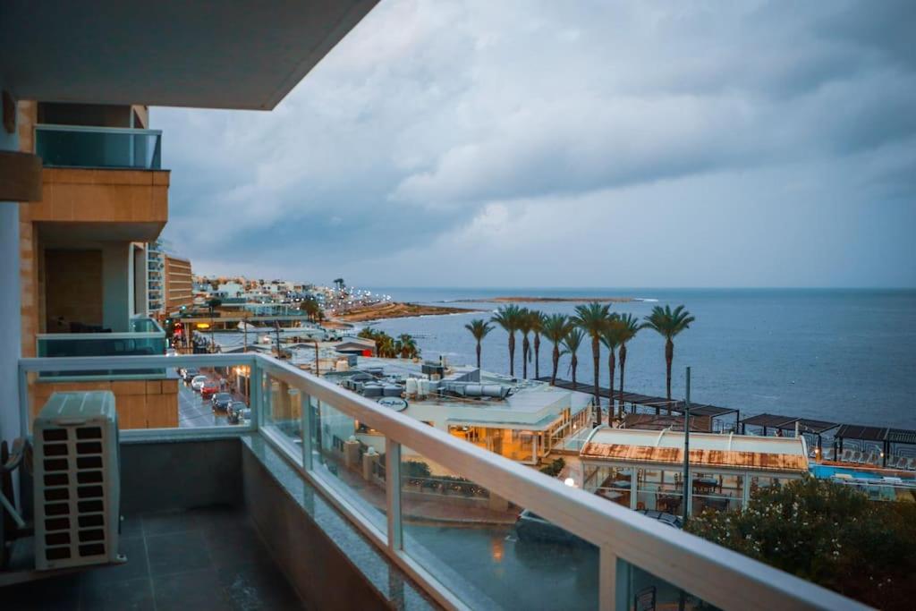 a balcony with a view of a marina and the ocean at Beachfront Apartment Bugibba in St Paul's Bay