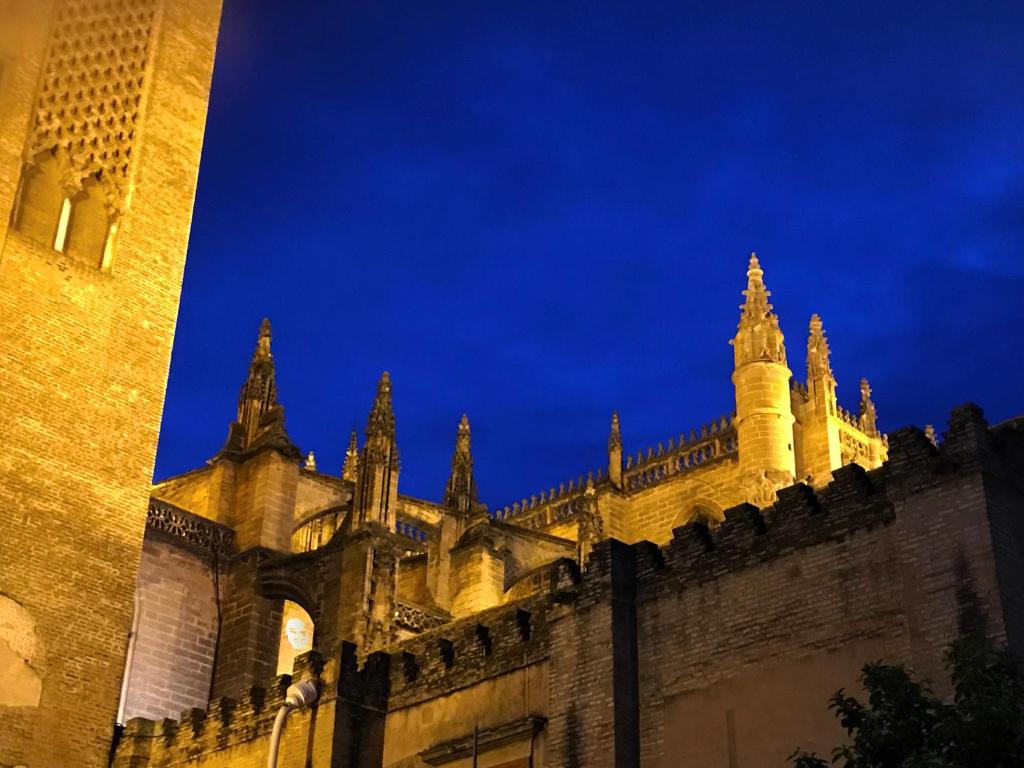 a building with a clock tower at night at Antigua Cestería in Seville