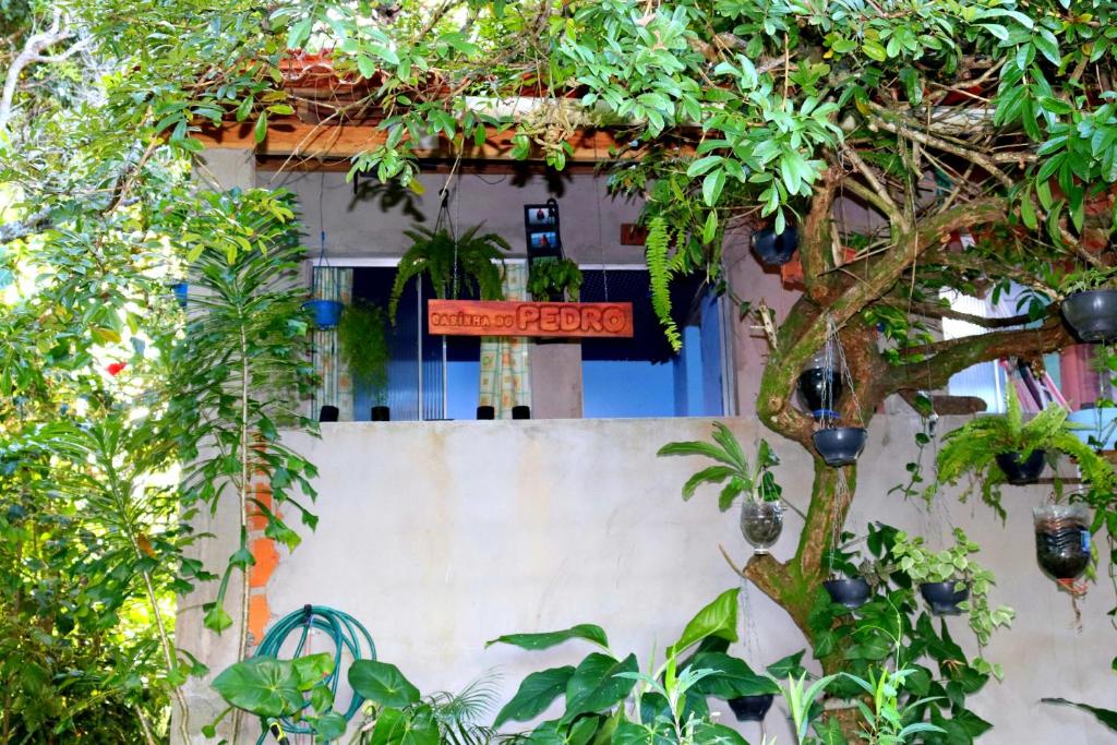 una señal en el lateral de un edificio con árboles en Casinha do Pedro - I love Boipeba, en Isla de Boipeba